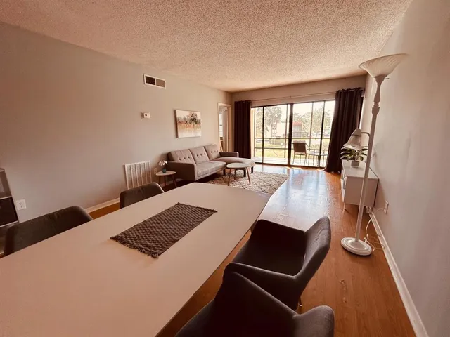 a bed room with a bed couches and a flat tv screen