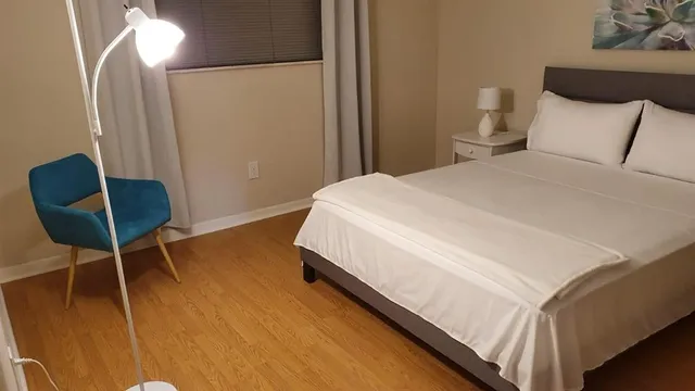 a large bed sitting in a bedroom next to a lamp