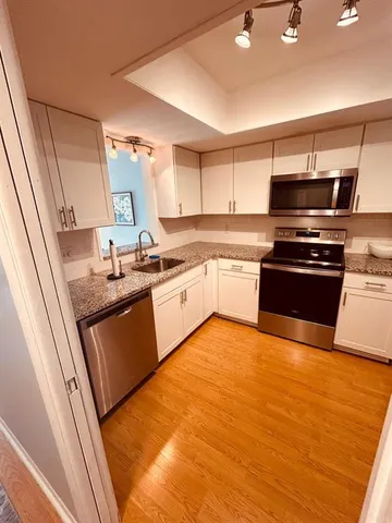 a kitchen with stainless steel appliances granite countertop a sink and stove top oven