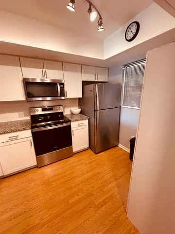 a kitchen with a refrigerator and a stove top oven