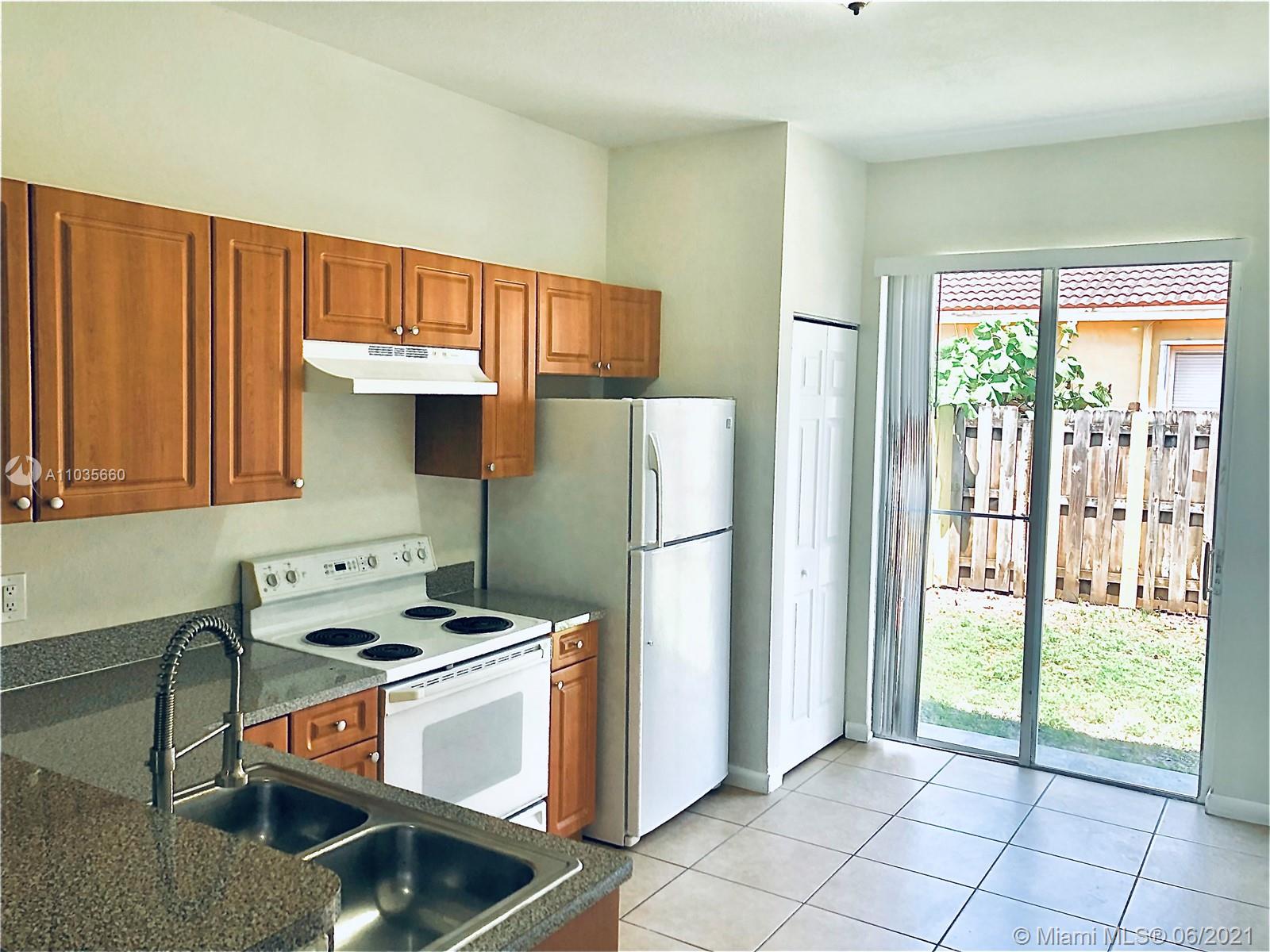 25 Southwest 15th Road, Unit 25 Homestead, FL 33030 - Photo 3 of 15 a kitchen with a stove a refrigerator and a sink