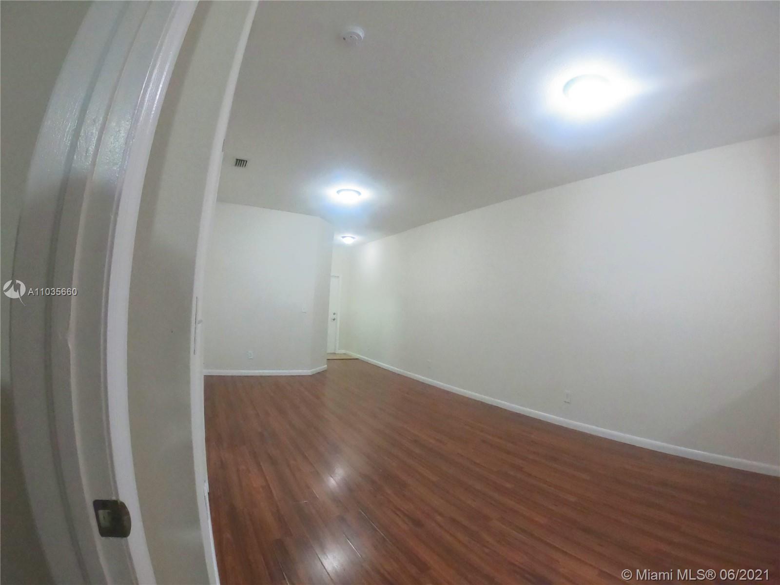 25 Southwest 15th Road, Unit 25 Homestead, FL 33030 - Photo 9 of 15 an empty room with wooden floor and windows