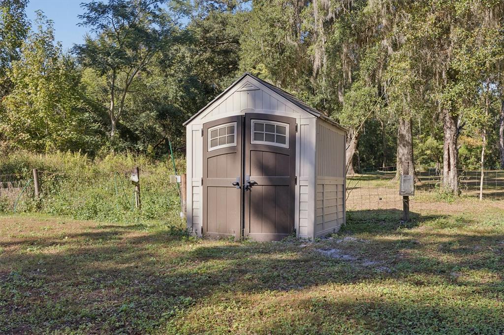 16607 Bearle Road Orlando, FL 32828 - Photo 19 of 57 a view of a small house with a yard and large tree