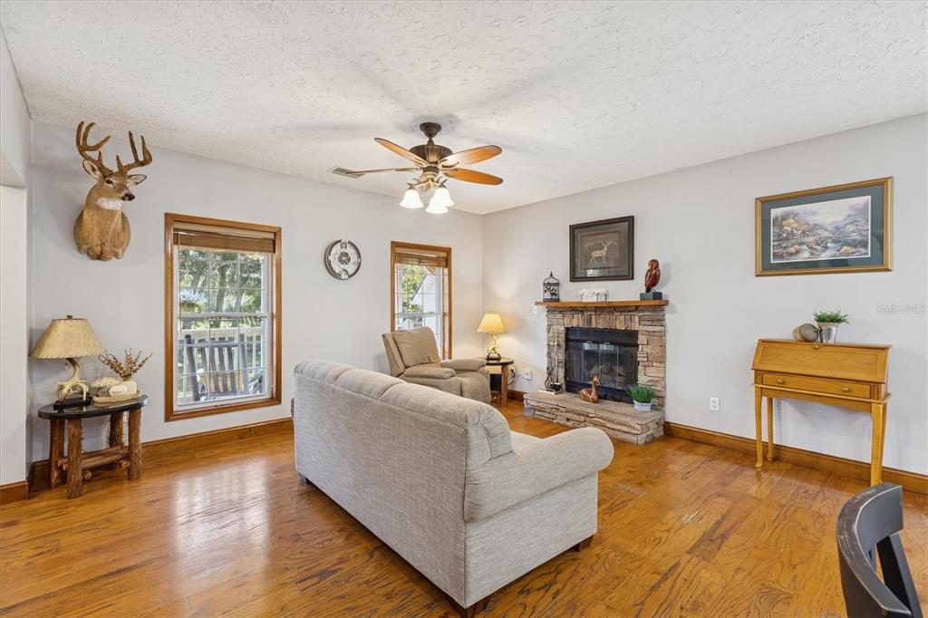 16607 Bearle Road Orlando, FL 32828 - Photo 28 of 57 a living room with furniture a fireplace and a flat screen tv