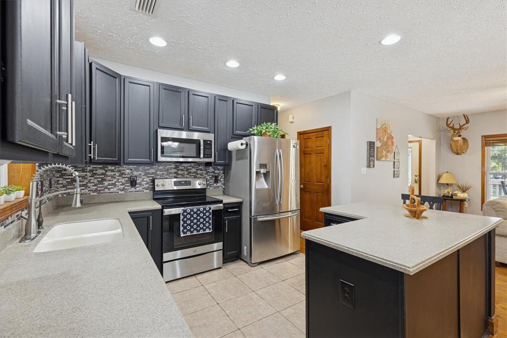 16607 Bearle Road Orlando, FL 32828 - Photo 32 of 57 a kitchen with refrigerator cabinets and furniture