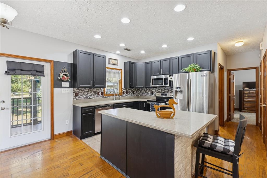 16607 Bearle Road Orlando, FL 32828 - Photo 33 of 57 a kitchen with a sink a stove and chairs