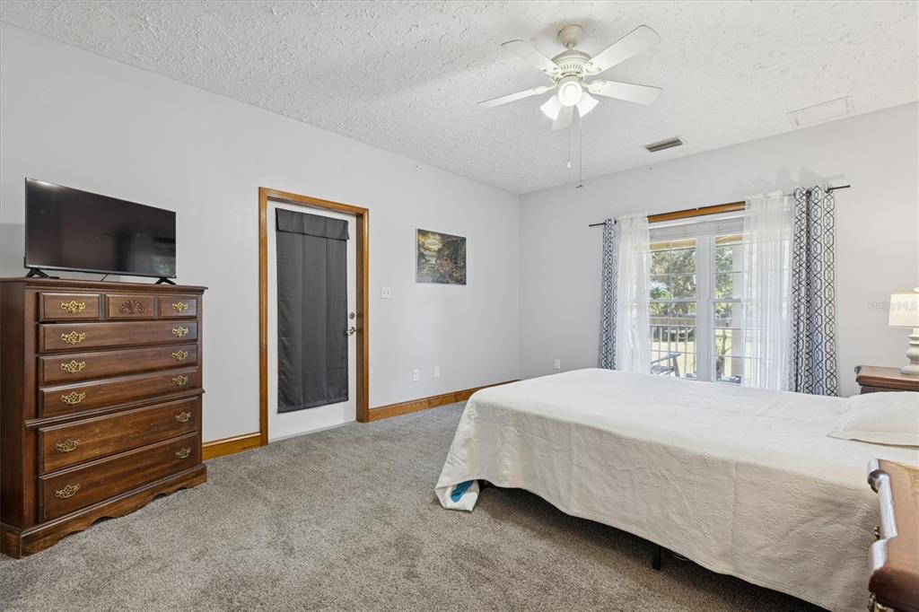 16607 Bearle Road Orlando, FL 32828 - Photo 38 of 57 a bedroom with a bed and a flat tv screen on dresser