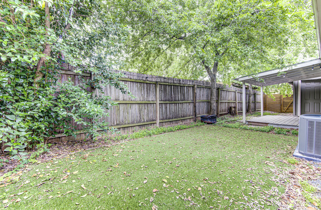 6713 West Gate Boulevard, Unit A Austin, TX 78745 - Photo 20 of 21 a view of a backyard with large trees and wooden fence