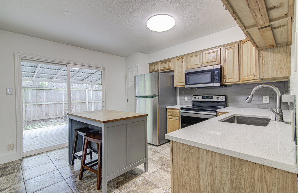 6713 West Gate Boulevard, Unit A Austin, TX 78745 - Photo 7 of 21 a kitchen view with stainless steel appliances a stove a sink and a microwave