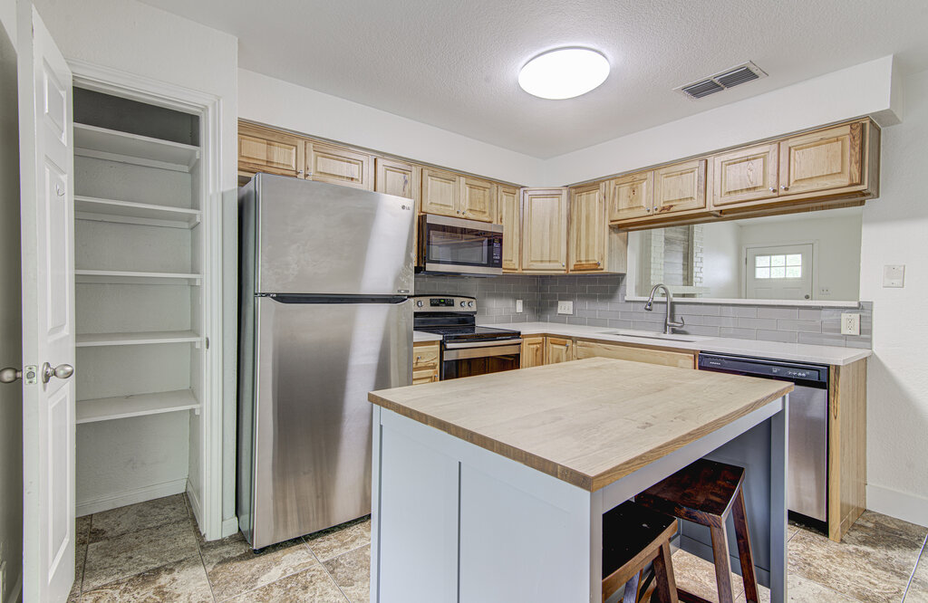 6713 West Gate Boulevard, Unit A Austin, TX 78745 - Photo 9 of 21 a kitchen with a refrigerator a stove a sink and a microwave