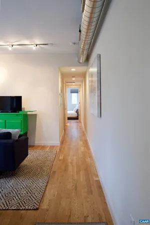 a hallway with wooden floor and stairs