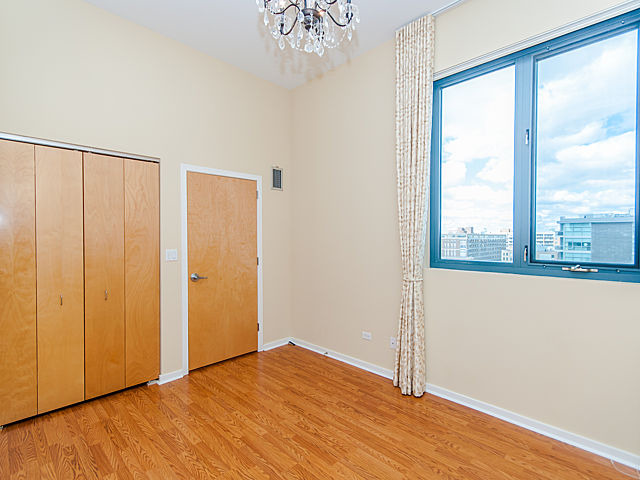 321 South Sangamon Street, Unit 901 Chicago, IL 60607 - Photo 15 of 18 a view of an empty room with wooden floor and a window