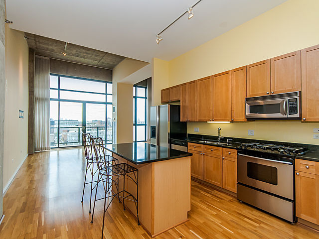 321 South Sangamon Street, Unit 901 Chicago, IL 60607 - Photo 2 of 18 a kitchen with stainless steel appliances granite countertop a stove top oven a sink and a table with chairs