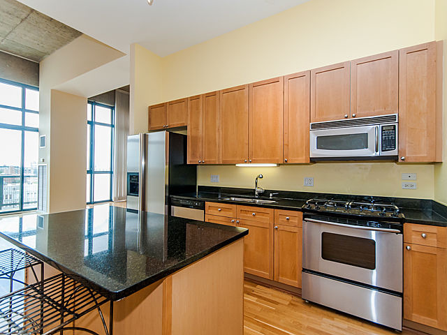 321 South Sangamon Street, Unit 901 Chicago, IL 60607 - Photo 3 of 18 a kitchen with stainless steel appliances granite countertop a stove a microwave a sink and white cabinets