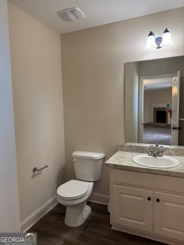a bathroom with a toilet a sink and mirror