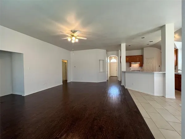a view of a livingroom with wooden floor and a ceiling fan