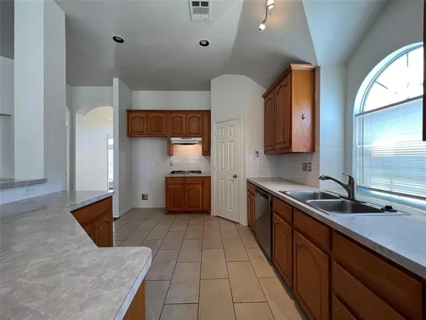 a kitchen with stainless steel appliances a sink and a refrigerator
