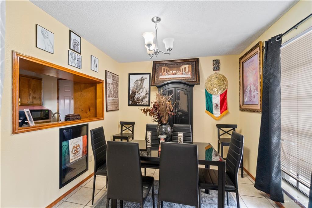 106 Rosa Priego Street Donna, TX 78537 - Photo 5 of 25 Dining room with a notable chandelier, a textured ceiling, and light tile patterned floors