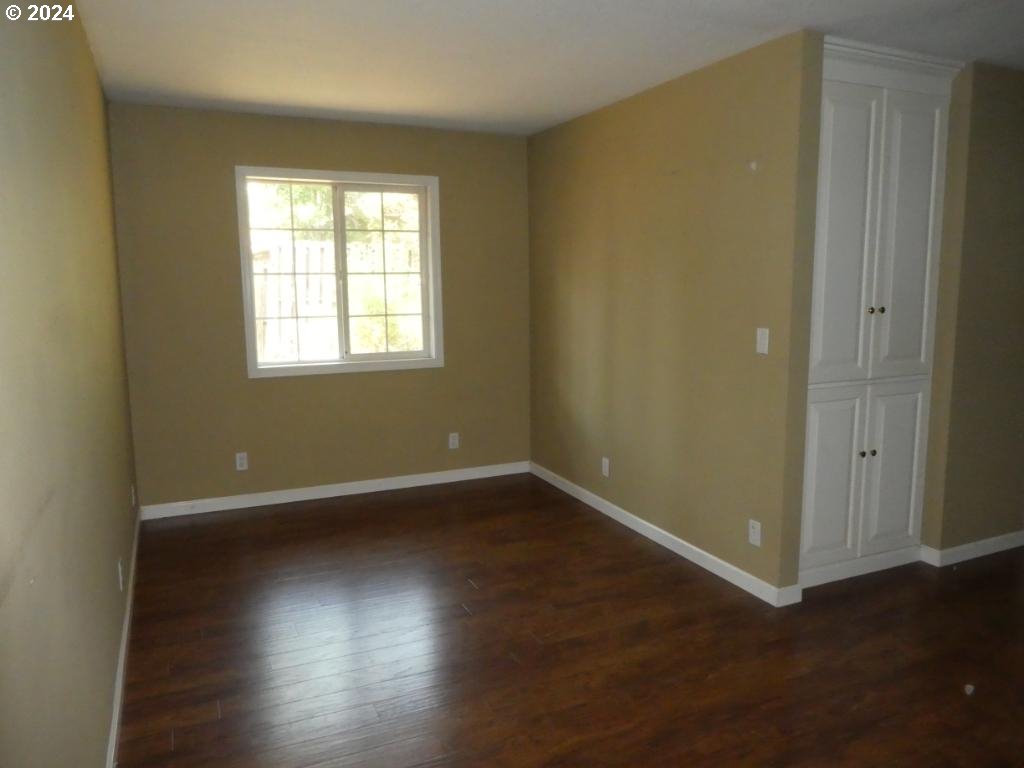 310 Southeast Terrace Drive Roseburg, OR 97470 - Photo 12 of 44 an empty room with wooden floor and windows with curtains
