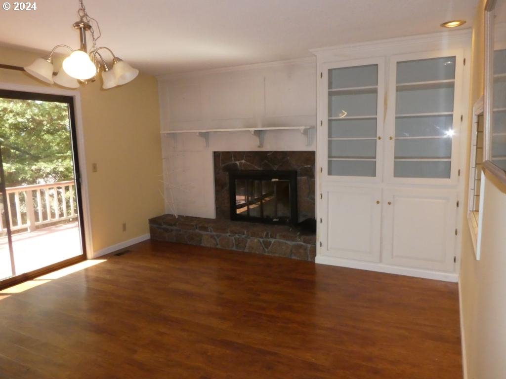310 Southeast Terrace Drive Roseburg, OR 97470 - Photo 18 of 44 an empty room with wooden floor fireplace and windows