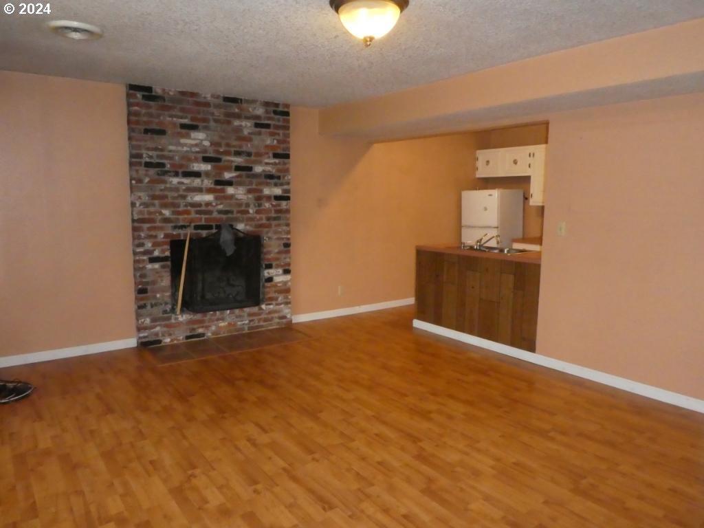 310 Southeast Terrace Drive Roseburg, OR 97470 - Photo 29 of 44 a view of an empty room with wooden floor and a fireplace