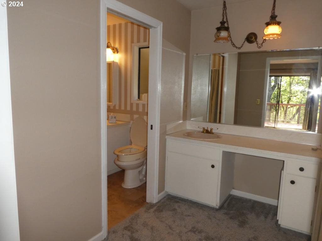 310 Southeast Terrace Drive Roseburg, OR 97470 - Photo 10 of 44 a bathroom with a granite countertop toilet a sink and a large mirror