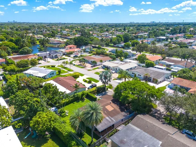 an aerial view of residential houses with outdoor space and trees