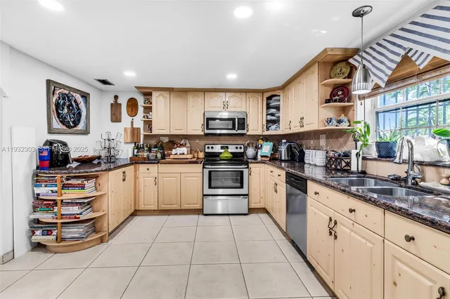 a kitchen with stainless steel appliances granite countertop a refrigerator and a stove top oven