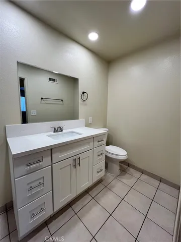 a bathroom with a double vanity sink mirror and toilet