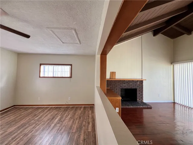 a living room with a fireplace and wooden floor