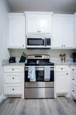 a kitchen with white cabinets and appliances
