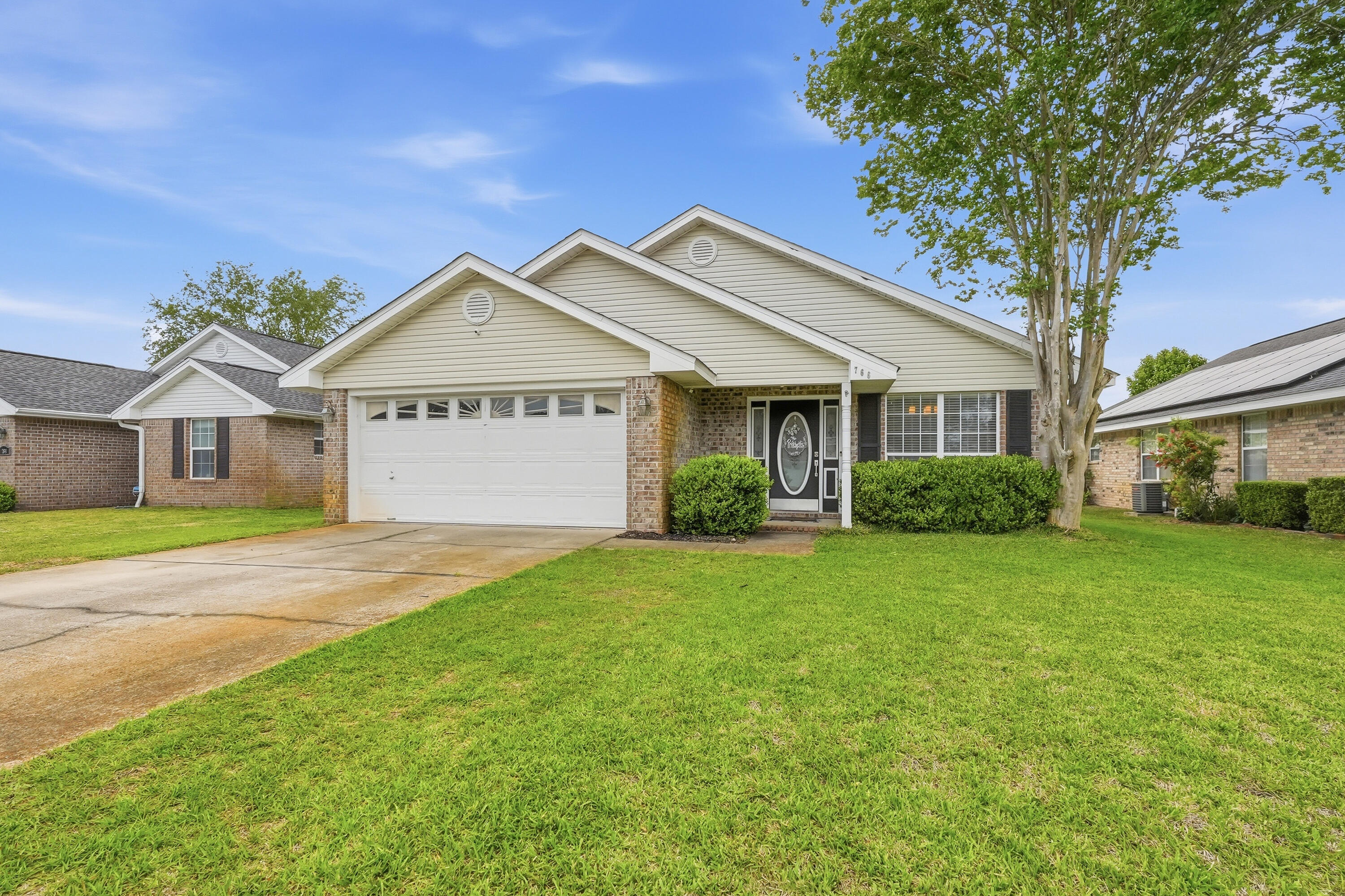 a front view of a house with a garden and yard