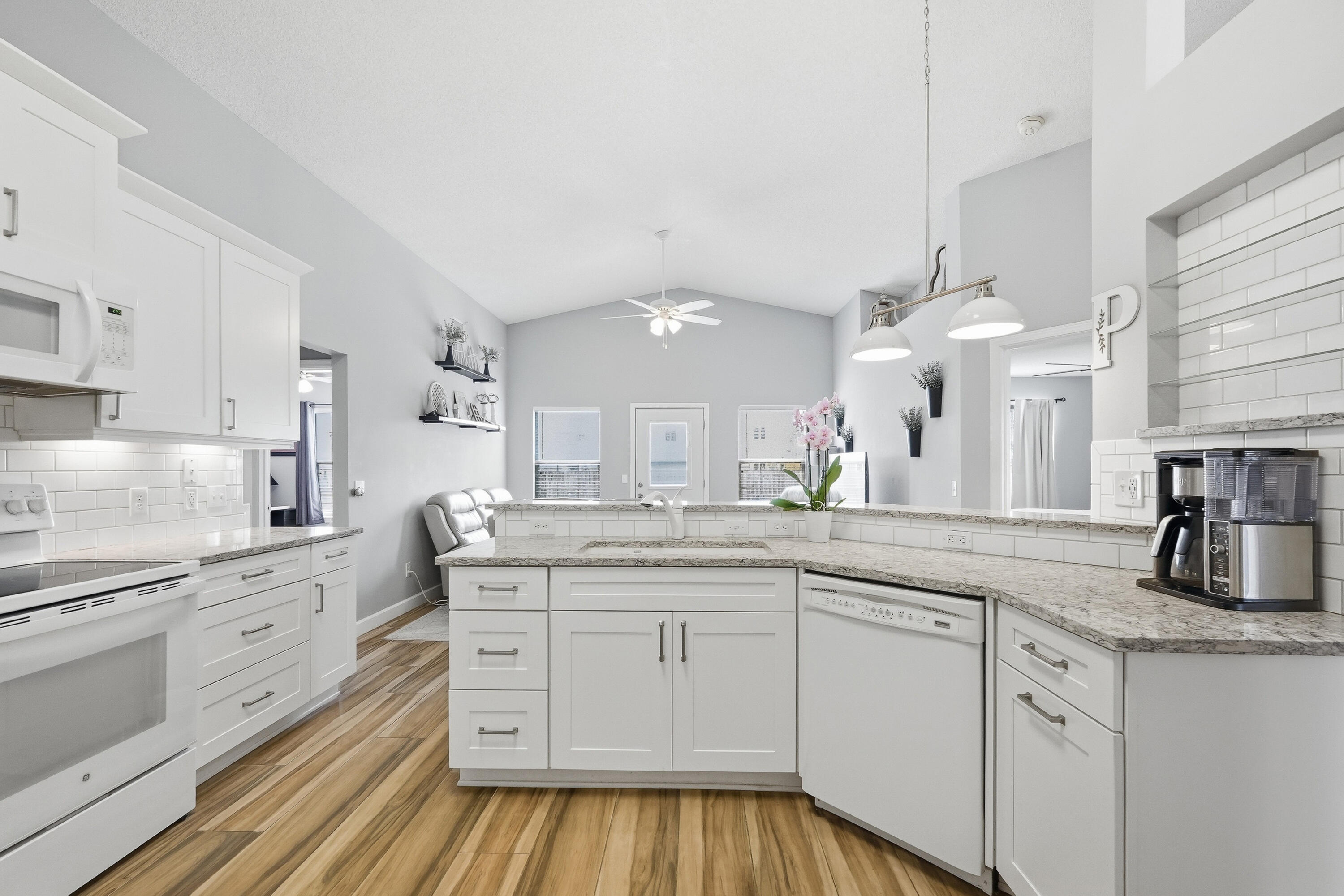 766 Randall Roberts Road Fort Walton Beach, FL 32547 - Photo 28 of 41 a kitchen with a sink dishwasher and white cabinets with wooden floor