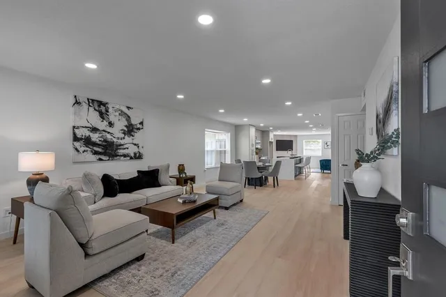 a living room with furniture and a wooden floor