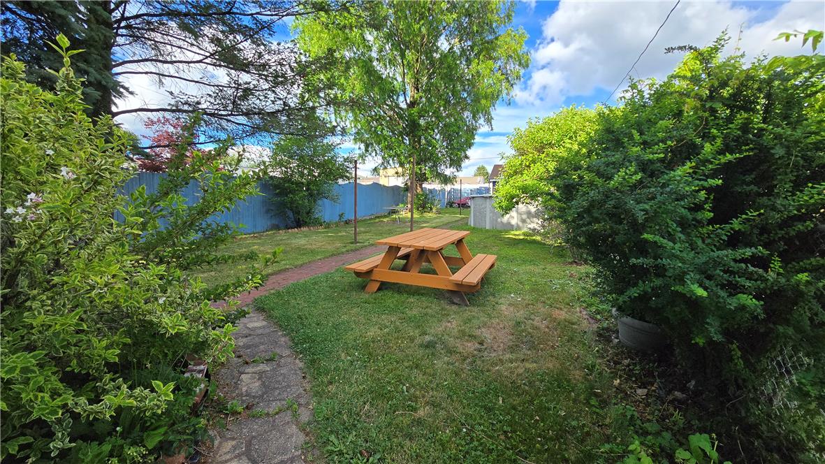883 North Locust Street Hazleton, PA 18201 - Photo 27 of 83 A private, verdant backyard sanctuary with a charming picnic table, perfect for outdoor enjoyment.