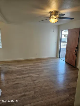 a view of empty room with wooden floor
