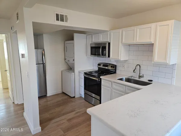 a kitchen with white cabinets and stainless steel appliances