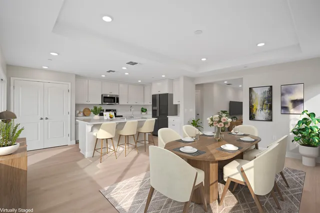 a view of a dining room and a kitchen with a table chairs
