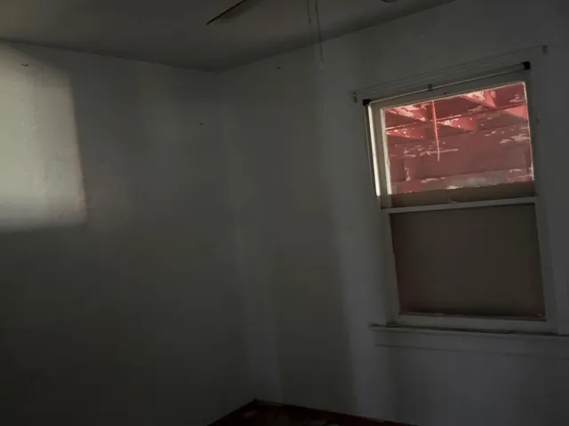 a view of room with window and a ceiling fan