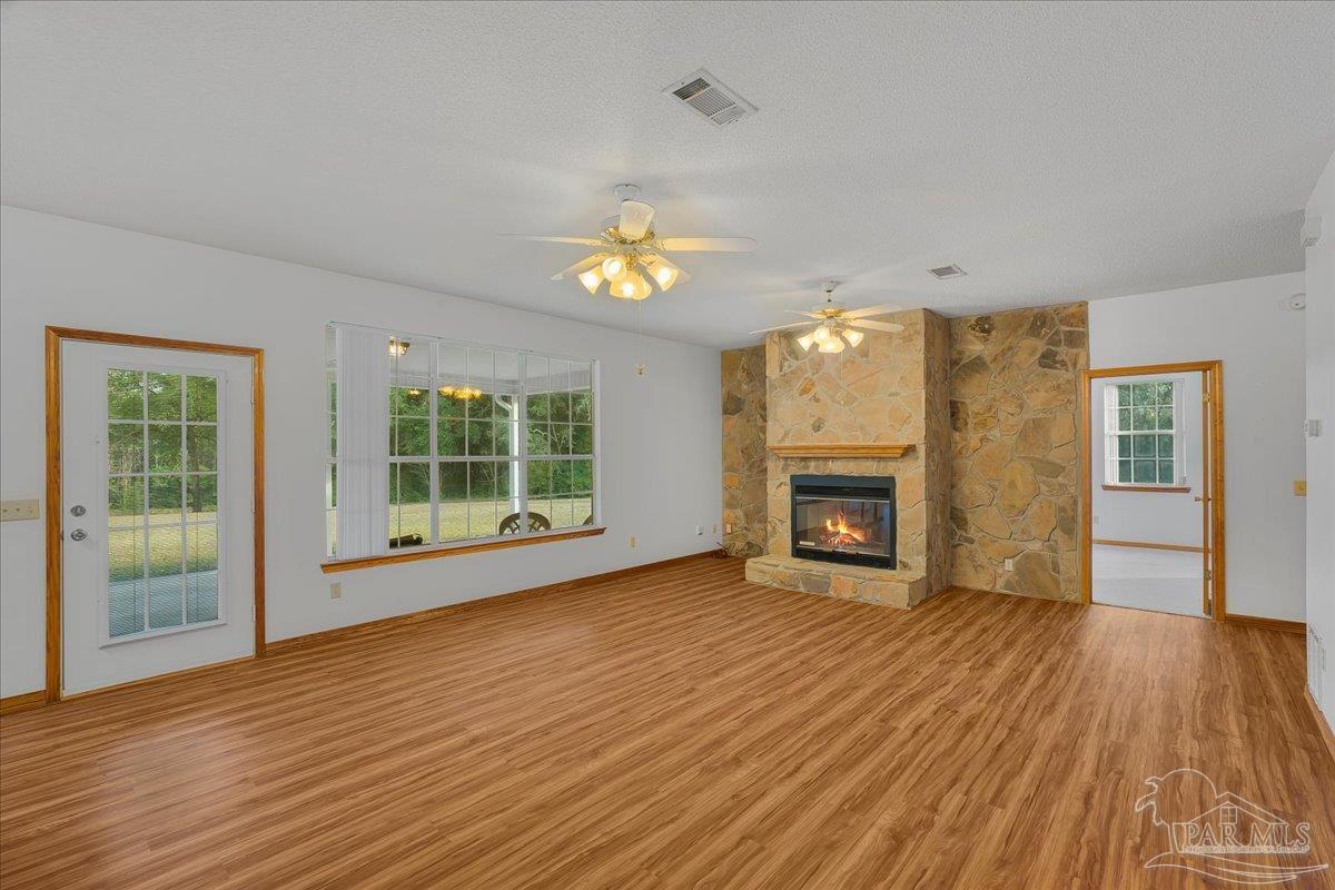 6500 Winston Brown Road Milton, FL 32570 - Photo 11 of 43 a view of an empty room with wooden floor fireplace and a window
