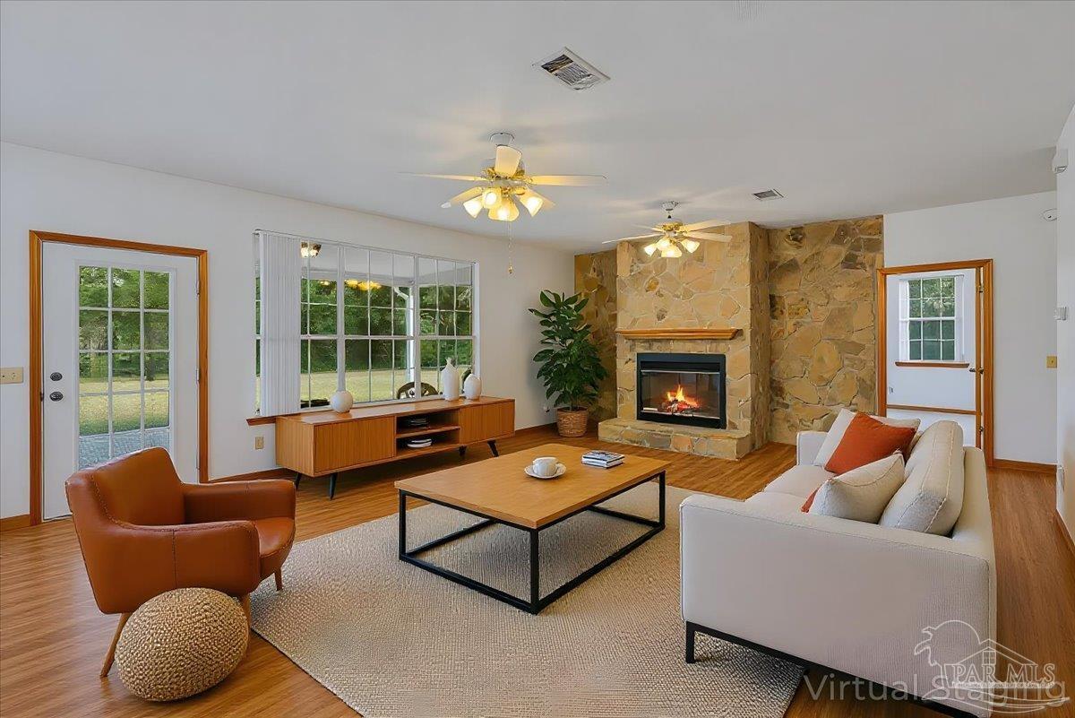6500 Winston Brown Road Milton, FL 32570 - Photo 12 of 43 a living room with furniture a fireplace and a large window