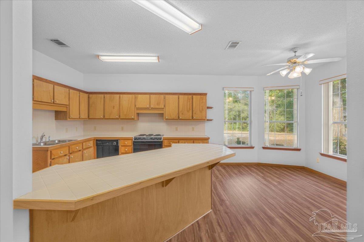 6500 Winston Brown Road Milton, FL 32570 - Photo 20 of 43 a kitchen with a stove a refrigerator and a window