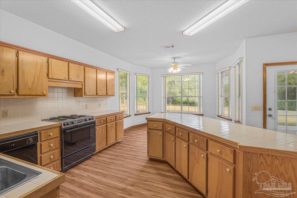 6500 Winston Brown Road Milton, FL 32570 - Photo 22 of 43 a large kitchen with stainless steel appliances granite countertop a stove and a sink