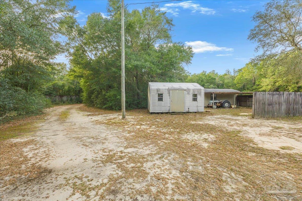6500 Winston Brown Road Milton, FL 32570 - Photo 41 of 43 a backyard of a house with large trees and wooden fence