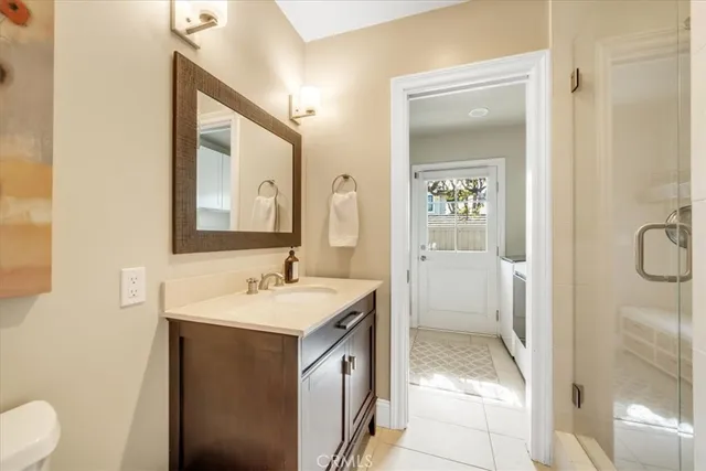 a en suite bathroom with a granite countertop sink mirror and a shower