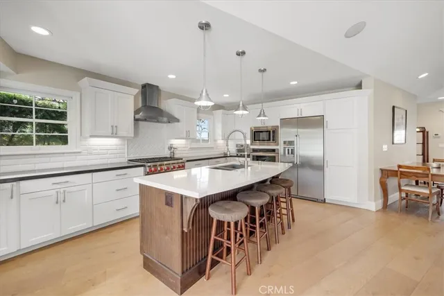 a kitchen with kitchen island granite countertop a sink a center island and stainless steel appliances