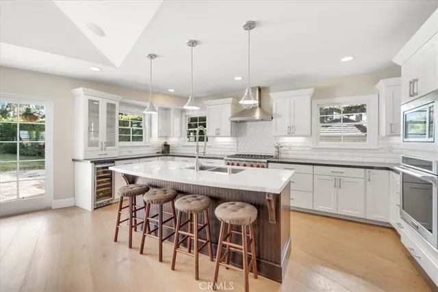 a kitchen with stainless steel appliances granite countertop wooden floor window and cabinets