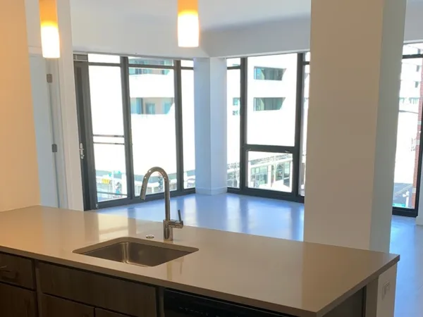 a view of a kitchen counter space with windows and wooden floor