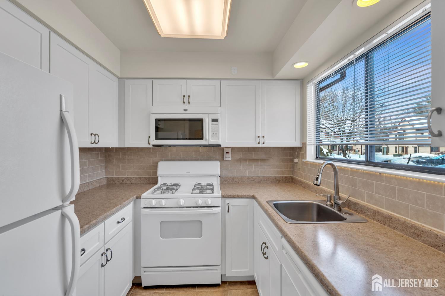 603 Jacob Court Dayton, NJ 08810 - Photo 5 of 18 a kitchen with white cabinets sink and white appliances