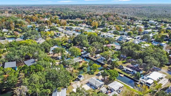 an aerial view of residential houses with outdoor space and lake view